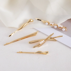 Vue détaillée du lot de 5 barrettes dorées avec des décorations de perles élégantes