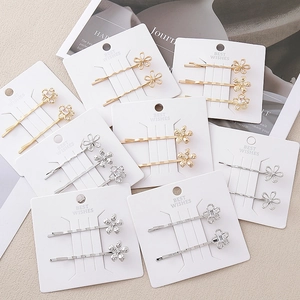 Barrettes à fleurs élégantes dorées et argentées avec cristaux sur carte de support