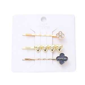 Three-piece gold hair clip set with rhinestone clover and metallic heart shapes