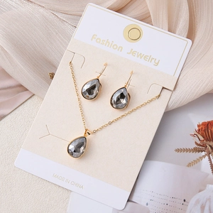 Detail van ketting en oorbellen set met rookgrijze kristallen in gouden zetting
