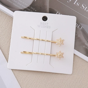 Barrettes à cheveux flocon de neige dorées avec cristaux blancs sur carte de mode chic