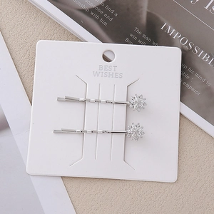Barrettes à cheveux flocons de neige argentées avec zircons sur carte de présentation