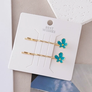 Barrettes à fleurs bleu clair chic avec finition dorée sur carte cadeau de présentation