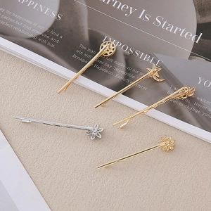 Détail d'un lot de barrettes dorées et argentées aux motifs célestes d'étoiles et de lune