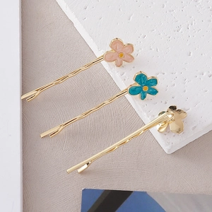 Détails de trois pinces à cheveux florales colorées avec épingles dorées ondulées et pétales