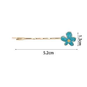 Détail d'une pince à cheveux fleur bleu ciel avec base dorée et dimensions indiquées