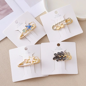 Golden sea star and rhinestone bow hair clip set with pearls on display card