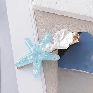 Starfish and shell hair clip with pearls and sequins on a polished gold metal base