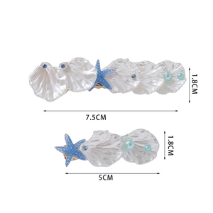 Macro detail of cream seashell and starfish hair clips showing precise size measurements