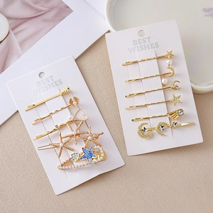 Set de barrettes dorées avec étoile de mer, lune et perles sur cartes blanches