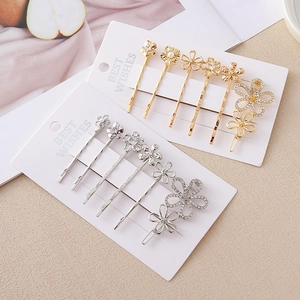 Détail d'un lot de barrettes à fleurs avec cristaux et perles sur cartes de présentation