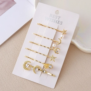 Coffret de barrettes dorées avec lune, étoiles, perles et strass sur carte de support