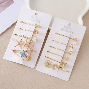 Coffret de barrettes dorées avec motifs étoile de mer et lune, détails perles