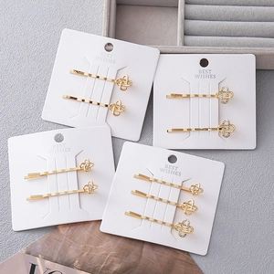 Set di eleganti fermagli per capelli dorati con strass e perle su scheda bianca