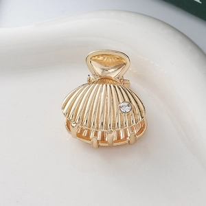 Elegant gold shell hair claw clip with rhinestones for a minimalist ocean-inspired hairstyle