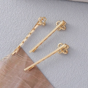 Dettaglio di fermagli per capelli dorati con eleganti fiocchi e rifiniture in strass