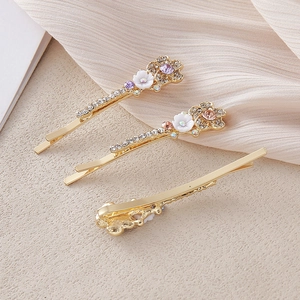 Gros plan de trois barrettes à fleurs en cristal avec placage à l'or sur de la soie
