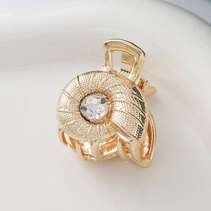 Detail of a mini gold alloy hair claw clip featuring a spiral design and sparkling zircon