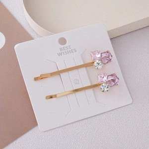 Elegant gold hairpin set with pink square crystals and white stones on display card