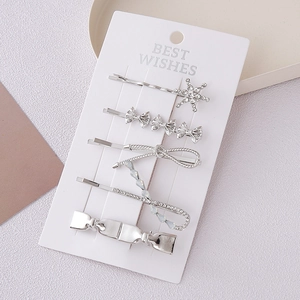 5-piece silver bow hair clip set with star shapes and rhinestones on display card