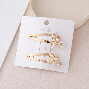 Elegant gold alloy pearl bow hair clips set on a minimalist white display card