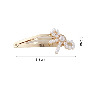Golden metal hair clip with white pearls in bow shape measuring 5.8cm in length