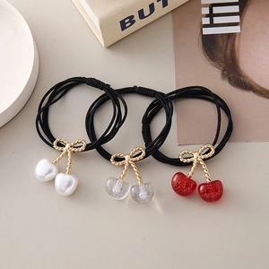 Lot de trois chouchous cerises avec nœuds dorés et perles de couleurs variées