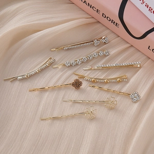 Elegant 8-piece gold rhinestone flower and clover hair clip set on silk fabric