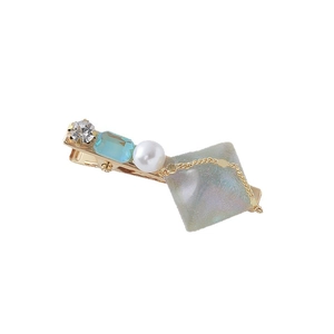 Eleganter goldener Haarclip mit Herzperle, blauem Edelstein und Kristall auf Weiß