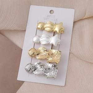 Star and geometric pattern hair clip set in gold and silver finish on display card