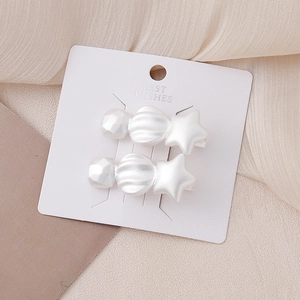 Chic cream star hair clips with matte pearl finish on a premium display card