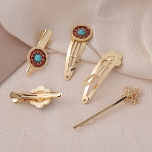 Detail view of 5-piece vintage alloy hair clips with turquoise patterns and gold knot designs