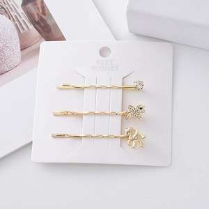 Three-piece gold unicorn hair clip set with rhinestones on a white display card