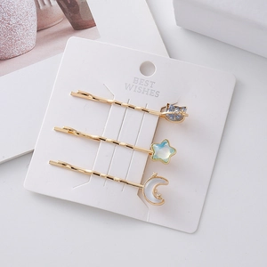 Set di tre fermagli per capelli dorati con ciondoli stella luna e gatto su scheda