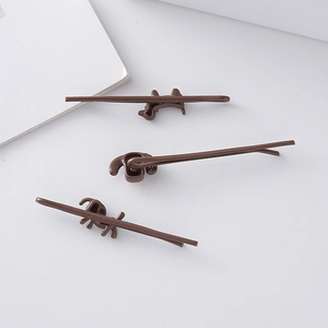 Three-piece set of brown cartoon dog hair pins displayed on a clean white background