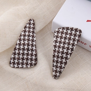 Pair of vintage houndstooth pattern triangle hair clips on a linen background