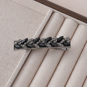 Detailed view of vintage black duckbill clip with marquise rhinestones and crystals