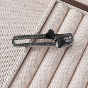Detailed close-up of dark grey alloy hair clip with micro-set rhinestones and heart crystals