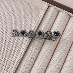 Detail of vintage flower hair clip with black and grey crystals on a metal duckbill base