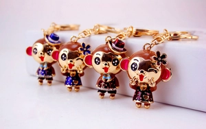 Detail of four colorful monkey keychains with crystal accents and gold-plated finish