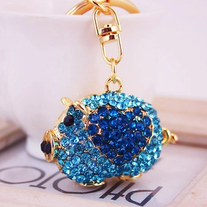 Porte-clés cochon doré mignon avec des strass bleus et une finition métallique élégante