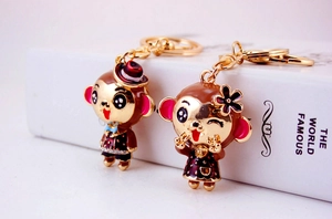 Detail of cute metal monkey couple keychains with enamel finish and crystal accents