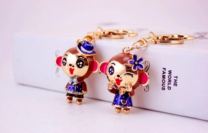 Detail view of cartoon monkey couple keychains with colorful enamel finish and gold ring
