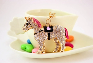 Detailed macro view of horse keychain with sparkling crystals and colorful enamel accents