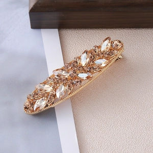 Detail view of champagne rhinestone hair clip with elegant golden alloy leaf patterns