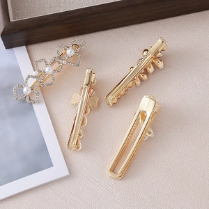 Close-up of gold hair clip set with white pearls, crystals and flower details