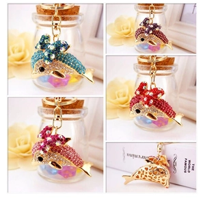 Detail of dolphin keychain with heart pattern back and colorful rhinestone bow