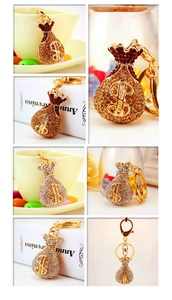 Detailed views of crystal-encrusted money bag keychain with dollar sign and gold hardware