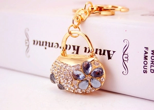 Detail of crystal handbag keychain with blue floral gems and golden lobster clasp