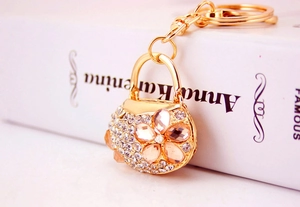 Macro shot of handbag-shaped keychain with gold alloy base and sparkling crystals